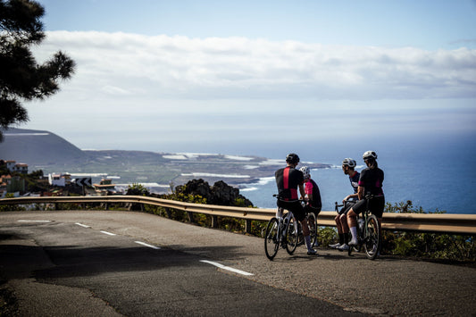 Cyclists stopping on a coastal road overlooking the sea