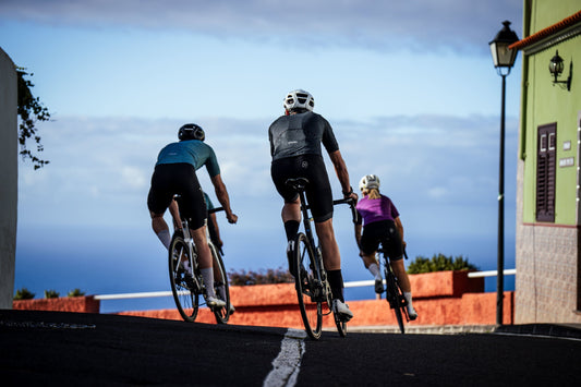 Three road cyclists riding on a coastal street