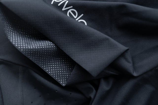 Close-up of Rivelo cycling short fabric showing laser-cut perforations and gripper texture
