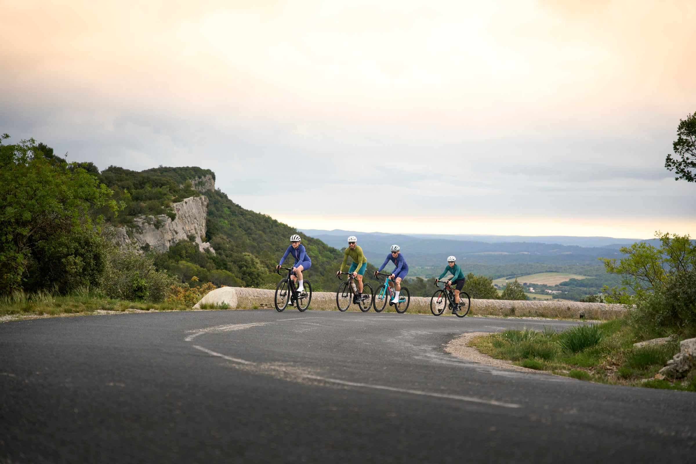 Four cyclists on a mountain road at dusk