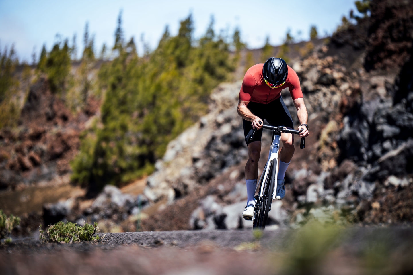 Cyclist climbing a rugged mountain road in bright sunlight