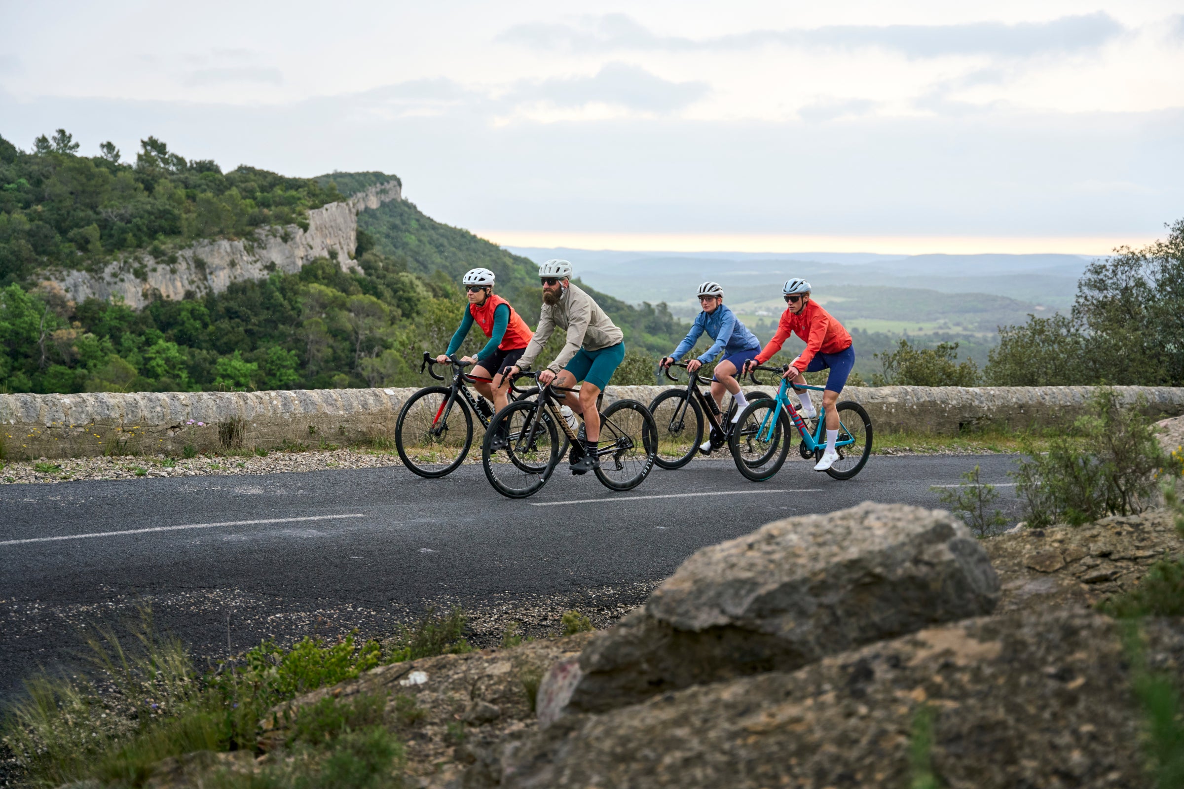 Four cyclists riding together on an open mountain road