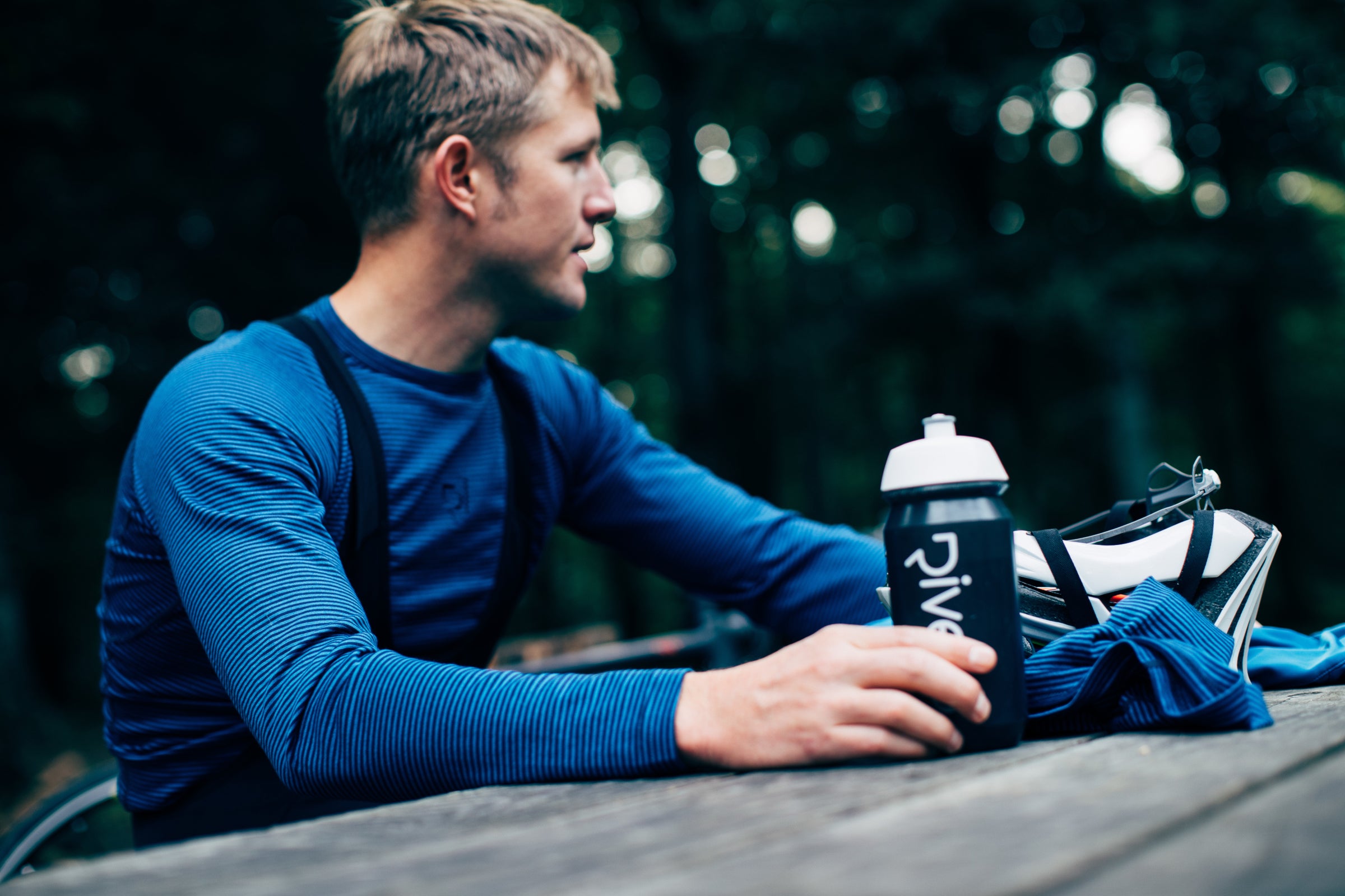 Man in blue shirt holding a black water bottle